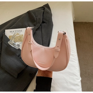 Pink crescent shoulder bag in pebble leather texture with adjustable silver buckle strap