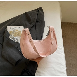 Close-up of pink pebbled leather hobo bag with adjustable strap and silver metal rivets