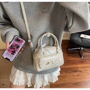 Detailed view of cream PU ballet style handbag with lace edges and bow decoration
