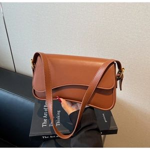 Détail du sac baguette marron caramel avec rabat magnétique et boucle dorée chic