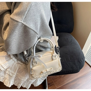 Creamy white bow handbag detail with delicate lace trim and detachable shoulder strap