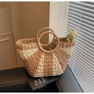 Close-up of contrast woven straw bag texture with beige and brown raffia fibers