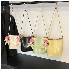Detailed view of four colorful bucket bags with cute puppy charms and pearl decorations