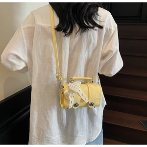 Vista dettagliata della mini borsa Boston gialla con fiocco in pizzo e perla