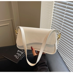 Détail du sac à bandoulière en cuir blanc avec boucles dorées et bandoulière élégante