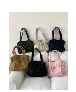 Sammlung von Nylon-Tragetaschen in sechs Farben auf einem weißen minimalistischen Sofa