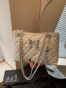 Chic cream quilted chain shoulder bag with silver bow accent and elegant metal strap
