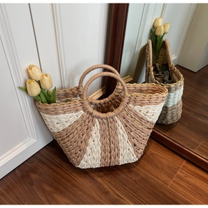 Close-up of woven straw bag showing two-tone radial pattern and shiny gold thread detail