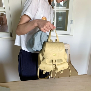 Close-up of a pale yellow lychee pattern leather mini backpack with dual front pockets