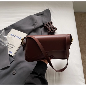 Vue détaillée du sac à bandoulière en cuir mat marron avec boucle dorée et sangle