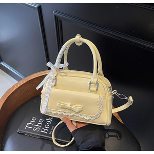 Close-up of yellow PU leather mini bag with lace bow details and blue checkered ribbon handle