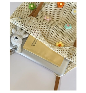 Detail view of woven knit tote bag with 3D colorful flowers and spacious interior