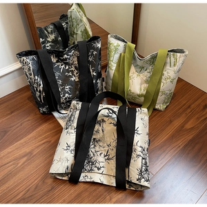 Three large canvas tote bags with bamboo prints displayed on a wooden floor in a cozy room