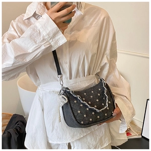 Détail du sac à bandoulière punk gris avec chaîne argentée et breloque en perles et dentelle
