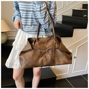 Detail of vintage brown leather tote bag with drawstring texture and large capacity
