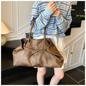 Detailed view of brown retro textured leather tote with sleek decorative strap buckle