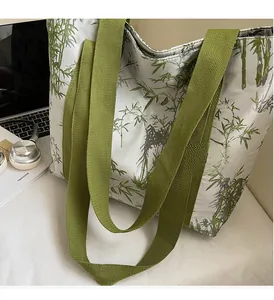 Detail of canvas tote bag featuring green bamboo print and durable wide webbing handles