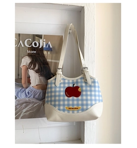 Detail of blue plaid fabric tote with red apple embroidery and white PU leather straps