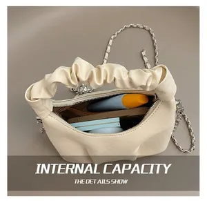 Internal view of beige ruched handbag with brown lining showing storage for smartphone