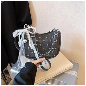Détail du sac demi-lune en denim gris avec chaîne argentée, perles et nœud dentelle