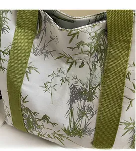 Detail of bamboo leaf print tote bag with thick green woven handle and soft fabric texture