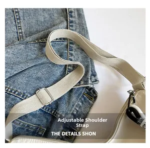 Détail de la bandoulière réglable avec boucle argentée sur le sac à bandoulière crème