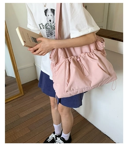 Große rosa Nylon-Umhängetasche mit Kordelzug-Design getragen an einer Person