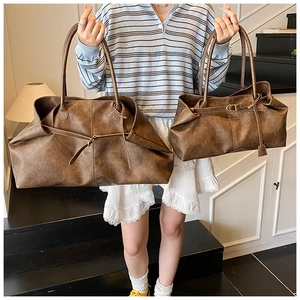 Detail of vintage brown tote bags showing matte leather texture and long shoulder straps