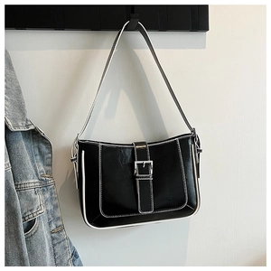 Detail of black crescent shoulder bag with white contrast stitching and silver buckle
