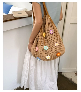 Detail of hand-woven crochet bag with floral 3D appliques and brown leather shoulder strap