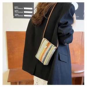 Detail view of the colorful woven rainbow crossbody mini bag with leather strap and drawstring