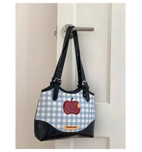 Detail of red apple embroidery and blue checkered canvas on this shoulder tote bag