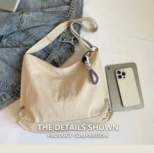 Détail du sac bandoulière en nylon plissé beige avec fermeture éclair tressée et sangle