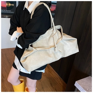 Detailed view of cream leather tote bag showing spacious design and strap on model