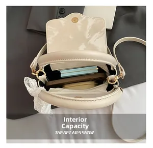 Top view of compact beige crossbody bag interior showing spacious capacity for phone and makeup