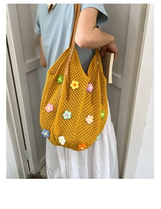 Detail of yellow knit tote bag featuring colorful 3D crochet flowers and leather handles
