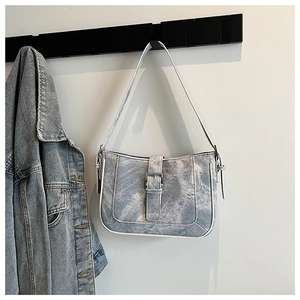Detail shot of vintage washed blue denim crescent shoulder bag with metallic buckle