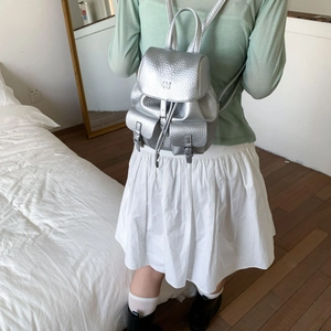 Silver metallic mini backpack with lychee texture and magnetic pockets on model