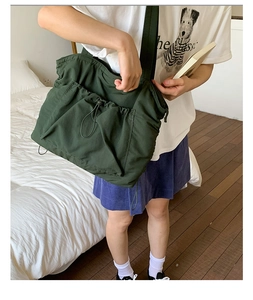 Detail einer dunkelgrünen großen Tragetasche mit funktioneller Kordelzugtasche auf der Front