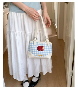 Blue plaid canvas tote bag with red apple patch and white leather strap details