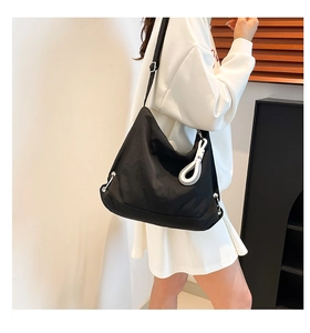 Détail du sac dumpling noir en nylon avec sangle réglable et pendentif en corde