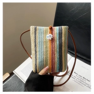 Detail of colorful rainbow woven straw mini bag with orange drawstring and leather strap