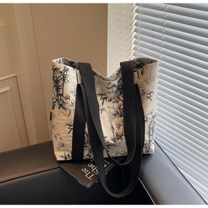 Detail of minimalist tote bag featuring black ink bamboo print and wide woven straps
