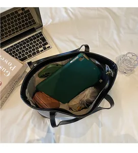 Spacious interior of black tote bag showing tablet, phone and folding umbrella storage