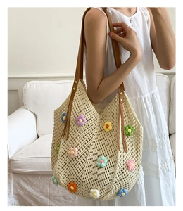 Detail of crochet floral tote bag featuring brown leather straps and colorful flowers