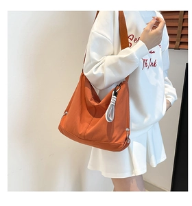 Vue détaillée du sac bandoulière léger en nylon orange vif avec large bandoulière de mode