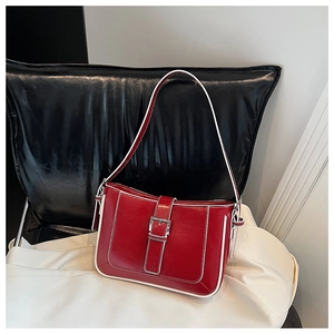 Detail view of red crescent bag with white contrast piping and silver metal buckle