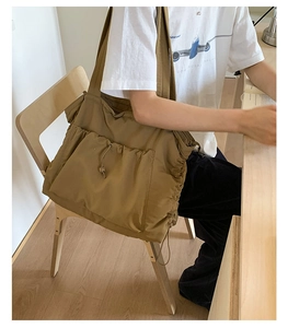 Detailansicht der khakifarbenen Shopper-Tasche mit Kordelzug und geräumiger Fronttasche