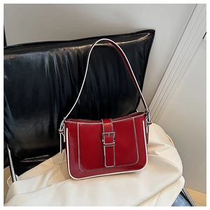 Detail of red vintage crescent bag with white contrast piping and silver metal buckle