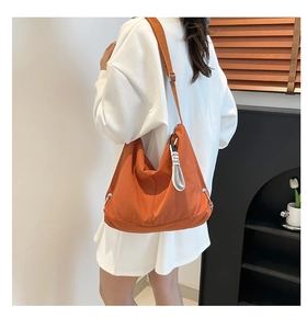 Vue arrière d'un mannequin portant le grand sac hobo orange vif en nylon imperméable